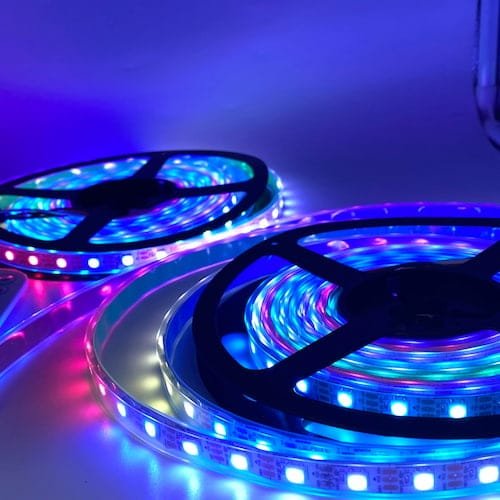 Dos carretes de tiras led RGB emitiendo luces brillantes y coloridas en tonos azul, púrpura y rojo.