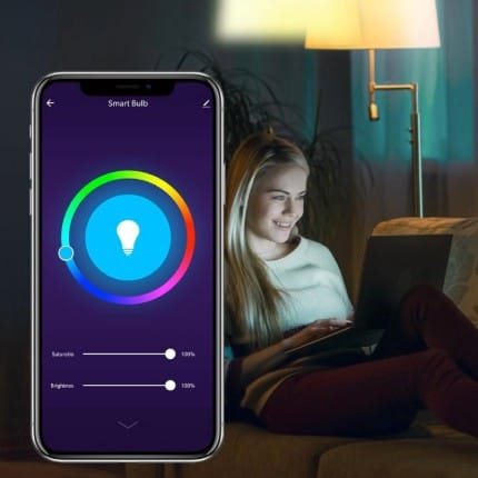 Mujer disfrutando de su portátil siendo alumbrada por la luz de una Bombilla inteligente Ngteco que controla con un smartphone